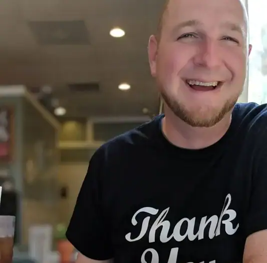 Smiling man wearing a "Thank You" t-shirt at Asheville Area Business Association event.