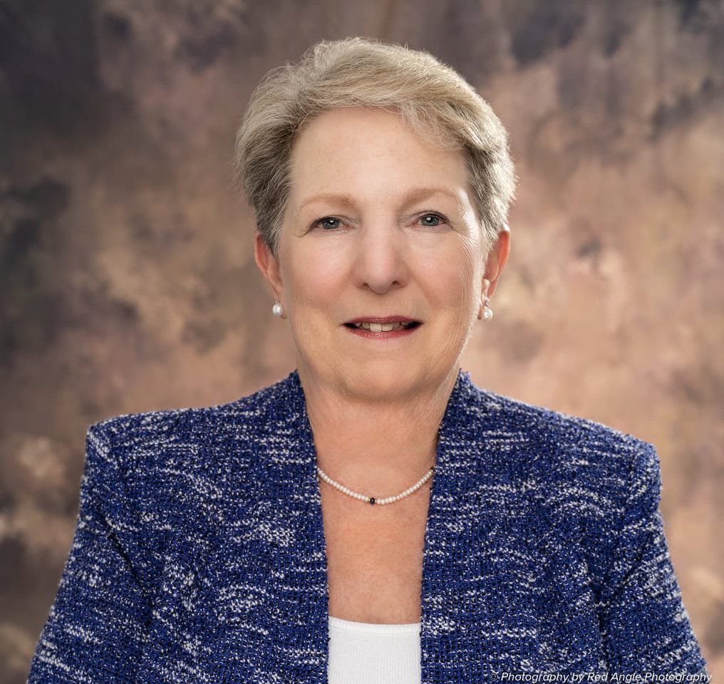 Confident senior woman in professional attire promoting Asheville area business association.