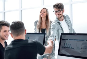 Friendly business team shaking hands during meeting at Asheville Area Business Association event.