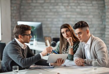 Business professionals discussing in a meeting at an office.